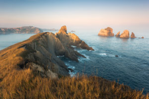 View over rugged coast at Santander / Liencres in first warm and soft morning light, Cantabria, Spain View over rugged coast at Santander / Liencres in first warm and soft morning light, Cantabria, Spain